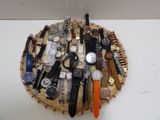 de nombreux modèles de montres exposés sur un plateau en bois