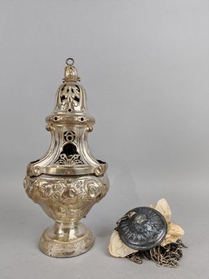 une image représentant une urne en argent et une chaîne posées sur une table