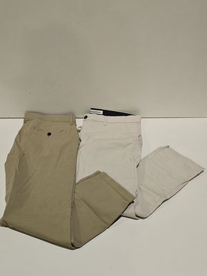 three pairs of pants and a cell phone on a table