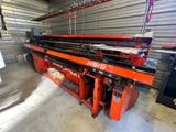 a red machine in a warehouse with a conveyor belt