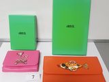 three different colored clutches are sitting on top of a table