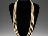 a three strand pearl necklace on a mannequin display
