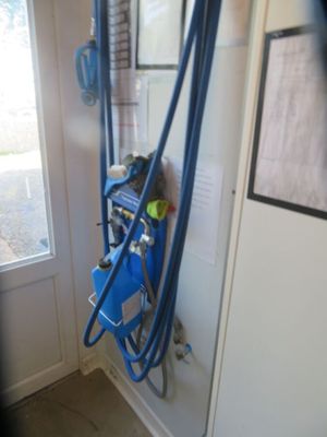 a blue hose attached to a wall next to a window