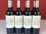 quatre bouteilles de vin sont alignées sur une table