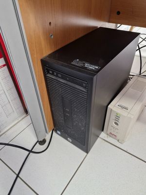 un ordinateur posé par terre sous un bureau