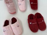 quatre paires de chaussons sont alignées sur une surface blanche