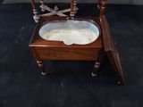 a wooden chair with a glass top on a black carpet