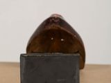 a brown vase sitting on top of a table next to a black box