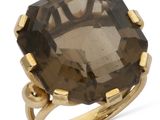 un gros plan d'une bague sertie d'une grosse pierre brune