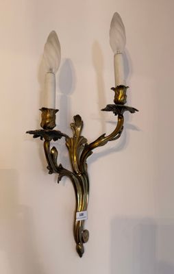 a wall mounted candle holder with two candles on it