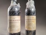 two bottles of wine wrapped in plastic sitting on a table