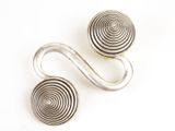 une paire de boucles d'oreilles en argent en forme de spirale sur fond blanc