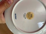 a person holding a white plate with a yellow label on it