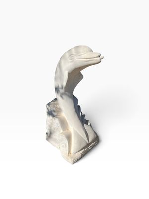 a close up of a statue of a bird on a rock