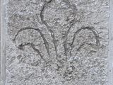 un gros plan sur une plaque en pierre ornée d'un motif de fleur de lys