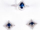 three pieces of blue sapphire and diamond jewelry on a white surface