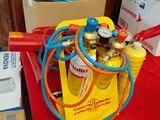 une table rouge sur laquelle sont posés tout un tas de bouteilles et de tuyaux