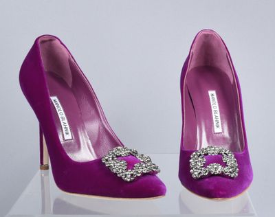 pair of purple high heeled shoes with jewel buckles on display