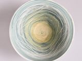 a white bowl with a blue and yellow swirl inside of it