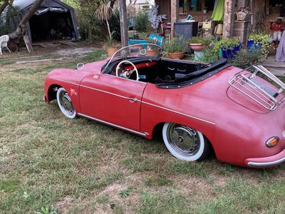 une voiture rouge garée dans l'herbe