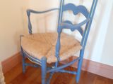 un chien debout à côté d'une chaise bleue dans une pièce