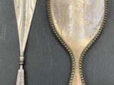 two silver spoons and a mirror on a table