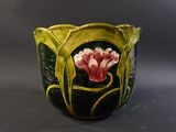 a close up of a vase with a flower painted on it