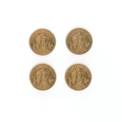 quatre types différents de pièces d'or sur une surface blanche