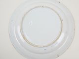 a white plate with a brown rim sitting on a table