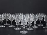 douze verres à vin en cristal alignés sur une surface noire