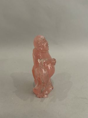a small figurine of a monkey on a white surface