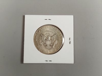 un gros plan d'une pièce de monnaie dans une boîte blanche posée sur une table