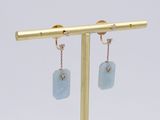 pair of aqua blue stone earrings on a gold plated stand