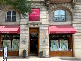 un bâtiment avec un auvent rouge et une enseigne sur la façade