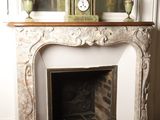 a fireplace with a clock on top of it in a room