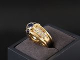 une image d'une bague en or avec une pierre bleue