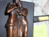 une statue représentant une femme tenant un bébé dans ses bras, posée sur une étagère