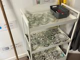 a cart with glass jars and a broom next to it
