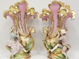 une paire de vases roses et dorés, ornés de motifs, sur un fond blanc