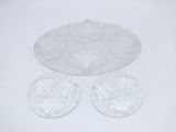three clear glass plates with flowers on them sitting on a white surface