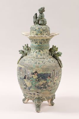 a large vase with a lid and a bird on it