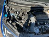 a blue car with the hood open and the engine in the trunk