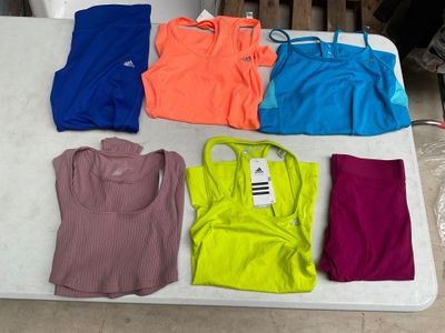 une table sur laquelle sont posés de nombreux t-shirts de différentes couleurs