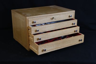a wooden box with three drawers on top of it
