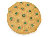 broche plaquée or ornée de pierres vertes sur fond blanc