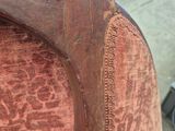 a close up of a wooden chair with a red upholstered upholstered back