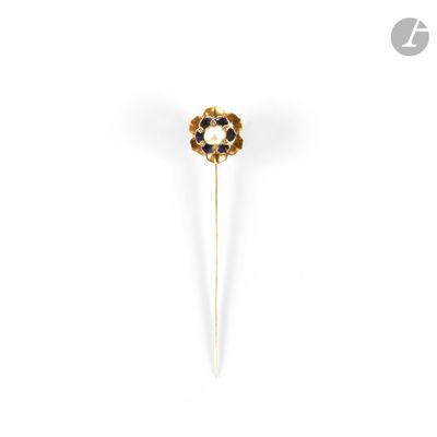 un gros plan sur une broche en forme de fleur dorée et noire