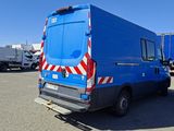 a blue van parked in a parking lot next to a blue car