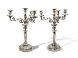 paire de chandeliers plaqués argent sur socles, sur fond blanc