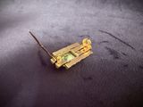 a small piece of gold with a green stone on it